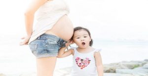 娘の近くに立つ妊婦