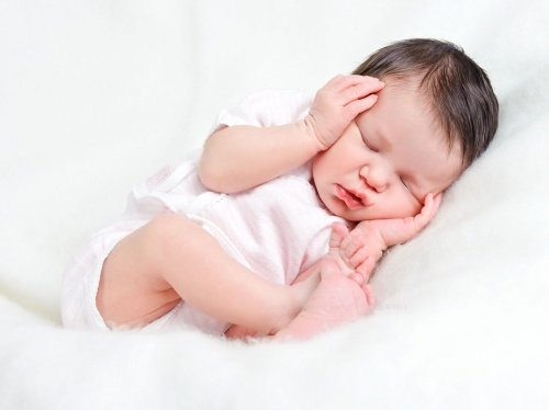 頭を抱えて眠る赤ちゃん