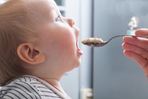 大きな口を開けて食べる赤ちゃん
