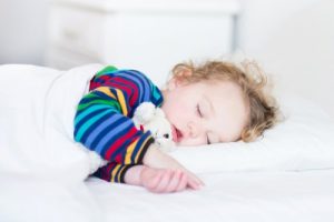 カラフルな服で昼寝をする男の子