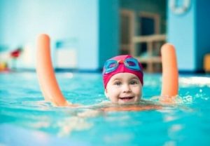 プールで浮き棒を使う子供