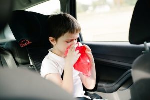 車内で口に袋をあてる男の子