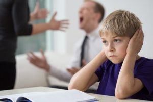 両親のケンカに耳をふさぐ男の子