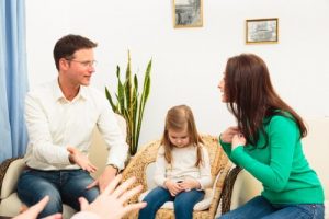 子供をはさんでケンカする両親