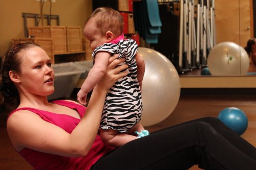 赤ちゃんとエクササイズをする女性