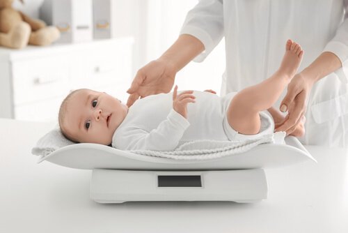 小児科で体重計に乗せられる赤ちゃん